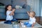 Cute little caucasian kids siblings laughing and playing at home show love and care, small girl sister embrace toddler brother,