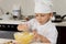 Cute little chef mixing ingredients as he bakes