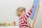 Cute little child drawing with chalk on a blackboard at home, creative and funny indoor activity for children