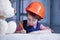 Cute little child girl architect in construction helmet planing