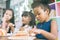 Cute little child girl with diversity friends eating cake together. kids eat dessert.