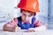 Cute little child girl engineer in construction helmet working w