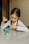 Cute little child girl painting with blue and yellow colors Easter eggs. Hands of a girl with a easter egg. Close-up