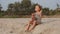 Cute little child girl playing drums on sandy beach.