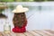 Cute little child girl in rubber boots and straw hat fishing from wooden pier near glass jar and little fish on a lake. Family