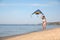 Cute little child with kite running at beach on day