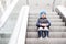 Cute little child sitting on moving staircase