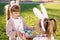 Cute little children with bunny ears and basket of Easter eggs