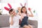 Cute little children in bunny ears headbands playing with Easter eggs