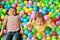 Cute little children playing in ball pit at amusement park