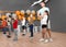 Cute little children and trainer doing physical exercise in school gym