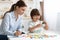 Cute little clever boy holding letter M, exercising with teacher at classroom, free space