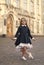 Cute little dance girl in school uniform make curtsy outdoors, dancing