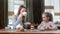 Cute little daughter and smiling mother enjoying family breakfast at cafe. Medium shot on RED camera