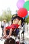 Cute little disabled girl in a wheelchair celebrate birthday or walking in the Park summer. Child cerebral palsy. Inclusion