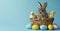 Cute little easter bunny in the basket with colorful eggs and yellow little chickens. Free space for text over blue