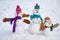 Cute little family snowman outdoor. Happy family of Snowman on a background snow-covered fir branches. Happy smiling