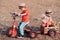 Cute little farmers - little boy and girl on tricycle on field. Two young farmers. Childhood on countryside, sweet