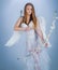 Cute little female cupid shoots a bow. Angel children girl with white wings. Innocent Girl with angel wings standing