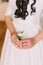 Cute little floral boutonniere in bride\'s hands. Close-up
