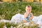Cute little funny baby child sitting in chamomile field