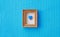 Cute little gingerbread heart in a wooden frame on a craft knitted blue background. handmade work. Flat lay composition