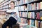 Cute little girl absorbed in reading book while sitting on small wooden ladder