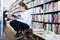 Cute little girl absorbed in reading book while sitting on small wooden ladder