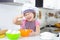 Cute little girl in apron cooking cookies