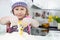 Cute little girl in apron cooking cookies