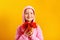 Cute little girl with an armful of autumn maple leaves on a yellow background