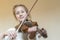 Cute little girl in a beautiful dress playing violin. Joyful and happy emotions. Training. Education. School. Aesthetic training.