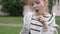 A cute little girl blowing on a white dandelion and its seeds scatter in different directions