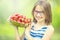 Cute little girl with bowl full of fresh strawberries. Pre - teen girl with glasses and teeth - dental braces