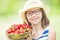 Cute little girl with bowl full of fresh strawberries. Pre - teen girl with glasses and teeth - dental braces