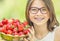Cute little girl with bowl full of fresh strawberries. Pre - teen girl with glasses and teeth - dental braces