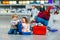 Cute little girl and boy at airport. Tired children, siblings sitting on ground and waiting for delayed flight. Kids