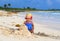 Cute little girl building sandcastle on the beach