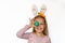 Cute little girl with bunny ears holding Easter egg, isolated on white background. Adorable child celebrate Easter holiday