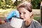 Cute little girl camping outdoors, drinking water.