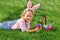 Cute little girl child with basket on green grass in the park. Easter Egg Hunting Concept