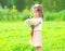 Cute little girl child with bouquet chamomiles flowers in summer