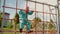 Cute little girl climbs rope wall, playing on playground