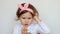 A cute little girl clothes headphones and listens to the song. The concept of music and relaxation. Close-up Funny child