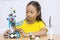 Cute little girl constructing a Lego robot in class