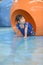 Cute little girl crawling on floor through tunnel in gym class