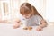 Cute little girl with cup of hot cocoa drink and cookies at home