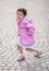 Cute Little Girl Dancing on a Cobblestone Pavement