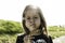 Cute little girl with dandelion flower in countryside during a spring sunny day - Female kid having fun and blowing the seeds of