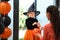 Cute little girl dressed as witch trick-or-treating. Halloween tradition